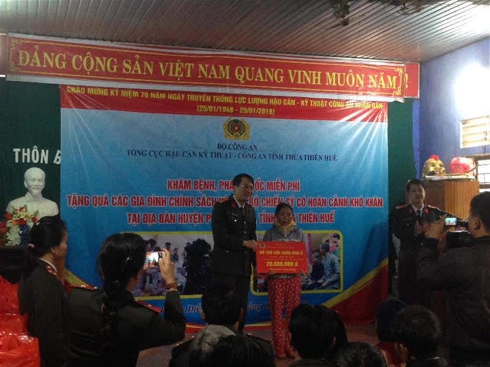 Đại diện lãnh đạo Tổng cục Hậu cần - Kỹ thuật Bộ Công an trao tặng số tiền hỗ trợ sửa chữa căn nhà cho bà Đồng Thị Tuyết.