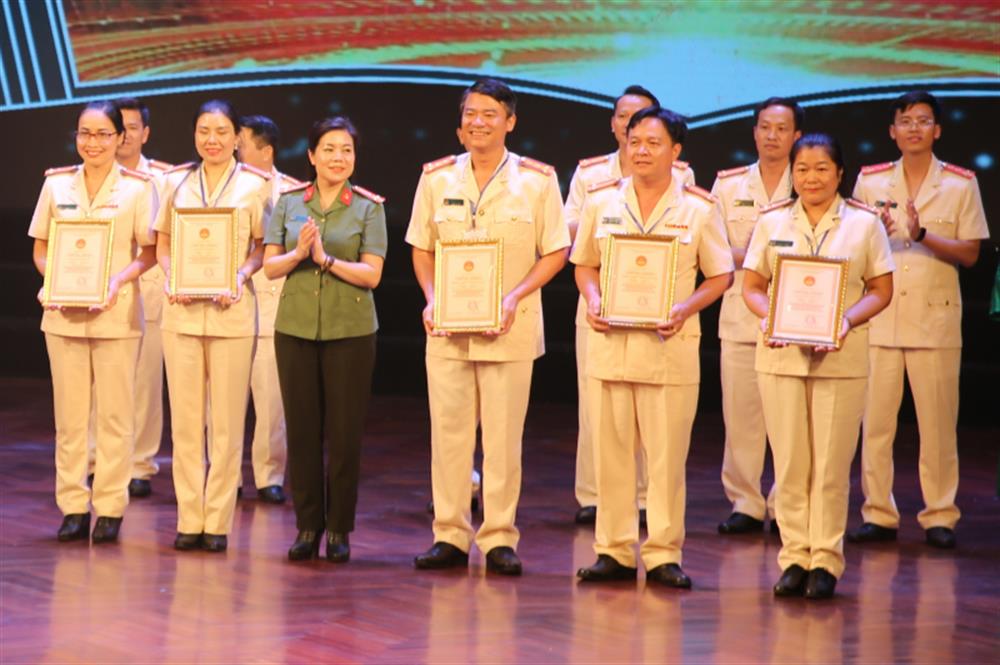Thượng tá, NSND Nguyễn Thị Thúy Hiền, Trưởng Phòng Văn hóa, văn nghệ, Cục Công tác Đảng và công tác chính trị trao Giấy chứng nhận tặng các đội thi đoạt giải chuyên đề.