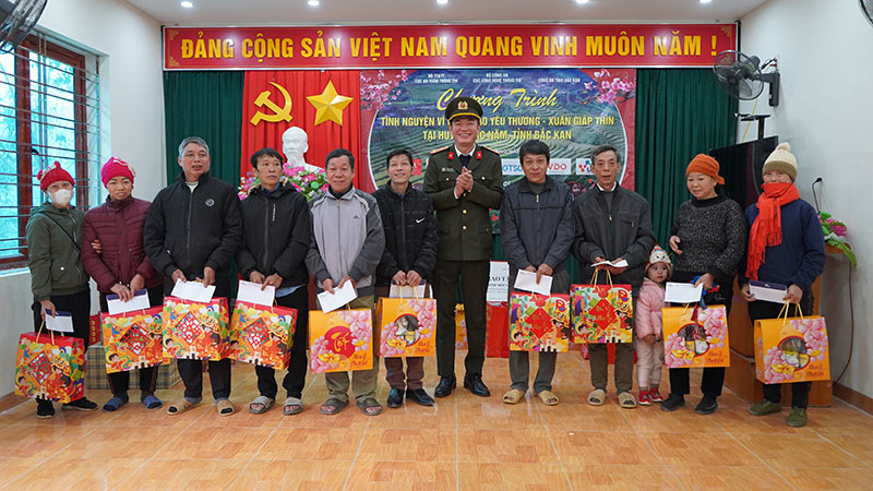 Đại tá Bùi Anh Tuấn, Phó Cục trưởng Cục Công nghệ thông tin trao quà tặng các hộ gia đình chính sách.