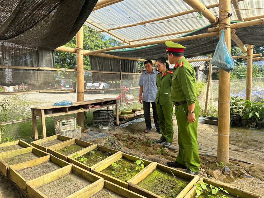 Cán bộ Công an xã tham quan mô hình và động viên anh Nông Văn Dích.