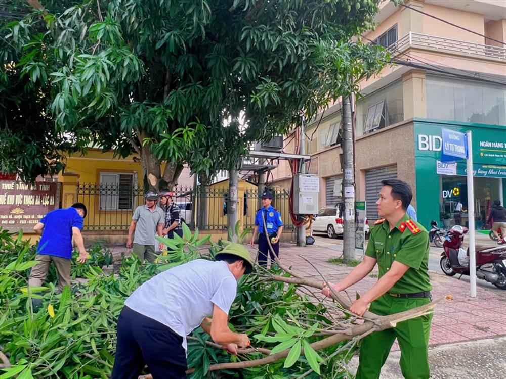 Lực lượng Công an xã hỗ trợ người dân cắt tỉa cây xanh.