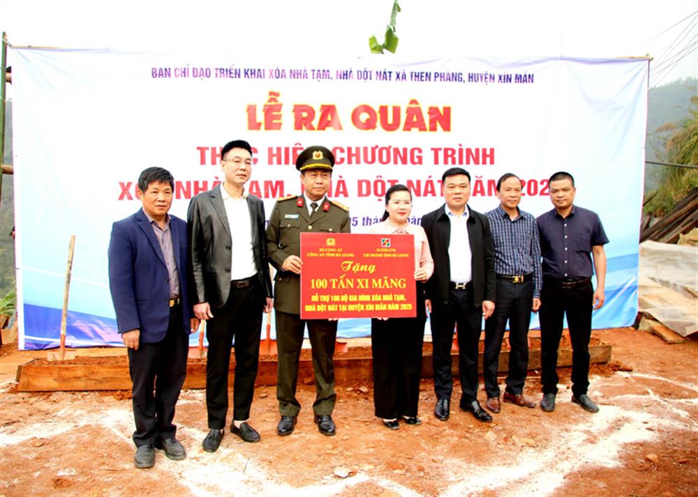 Đại tá Nguyễn Đức Thuận, Giám đốc Công an tỉnh và lãnh đạo Agribank Chi nhánh tỉnh Hà Giang trao xi măng hỗ trợ các hộ dân xóa nhà tạm, nhà dột nát trên địa bàn huyện Xín Mần.  
