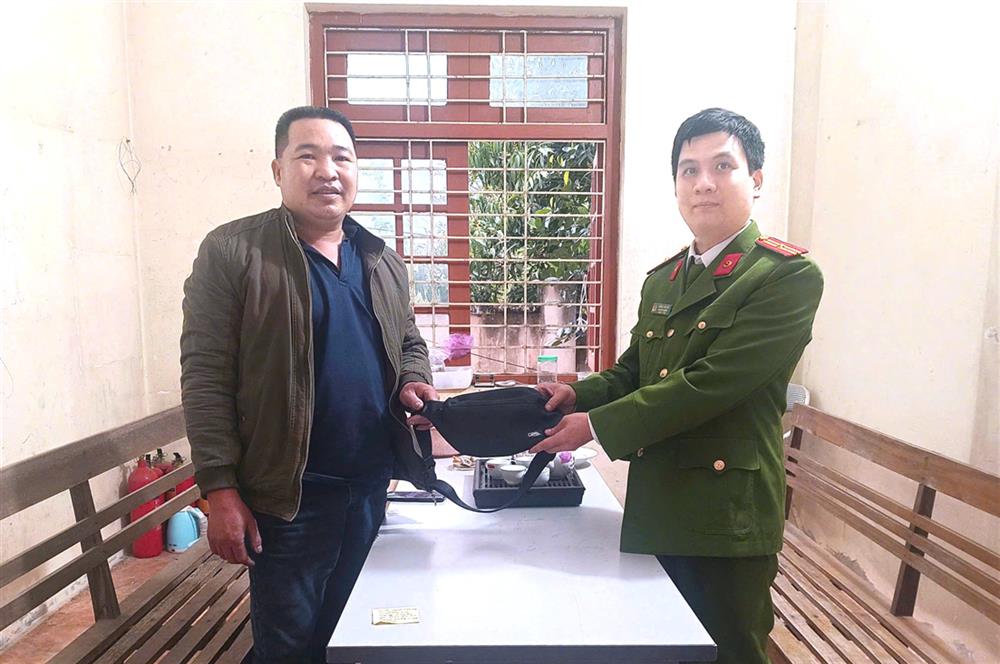 Thiếu tá Dương Văn Hiệt, Trưởng Công an xã Yến Dương tiếp nhận tài sản từ anh Nông Văn Duyến.