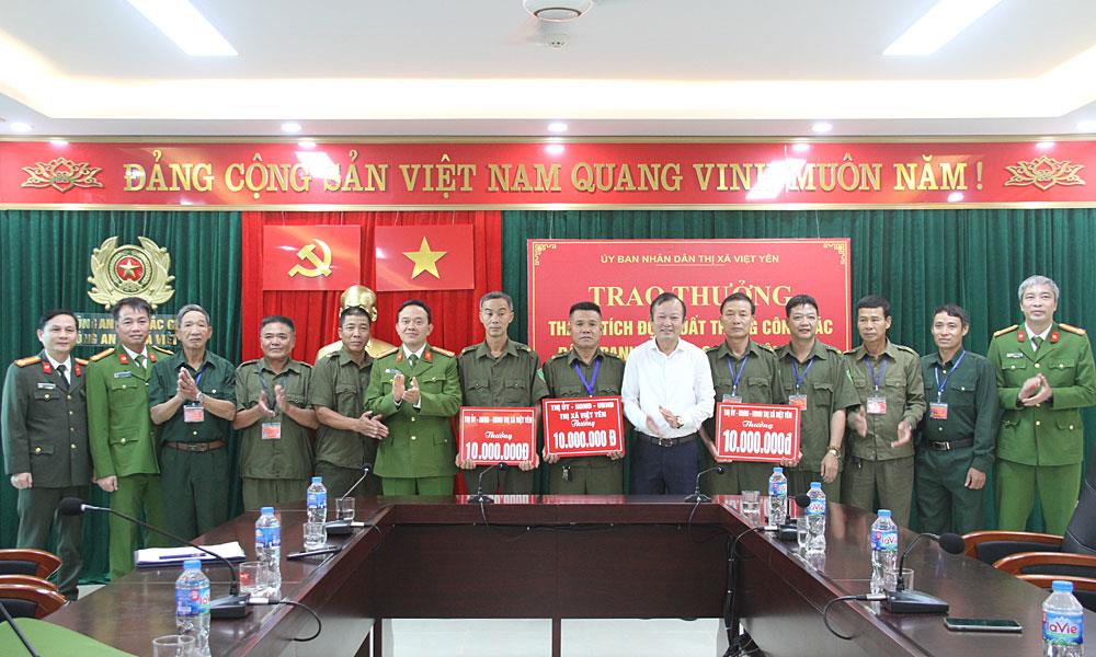 Anh Nguyễn Văn Bắc (đứng thứ 5 từ phải sang) đại diện Tổ ANTT ở cơ sở tổ dân phố Quang Biểu được Chủ tịch Ủy ban nhân dân thị xã Việt Yên trao thưởng.
