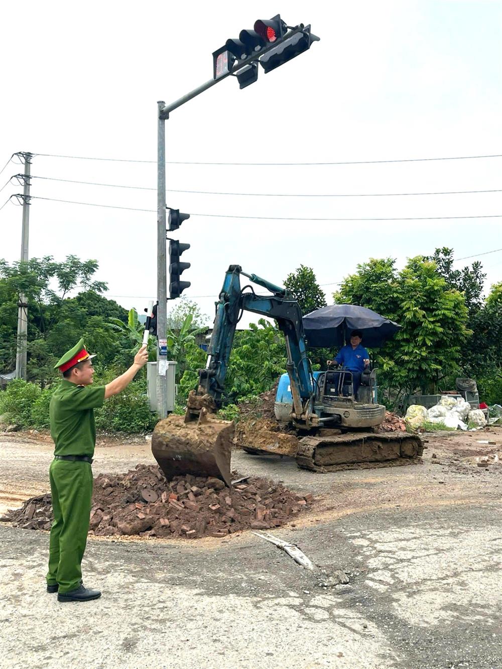 Thượng uý Giáp Tuấn Vũ phối hợp đoàn viên thanh niên xã Liên Bão tham gia xử lý giao thông phục vụ công tác sửa chữa trên một số đoạn đường thuộc địa bàn.
