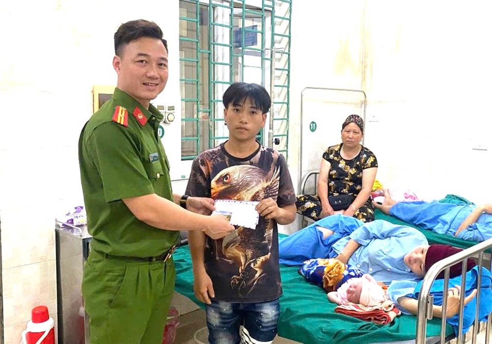 Thiếu tá Đặng Ngọc Cường đến thăm và tặng quà mẹ con chị Say tại bệnh viện.