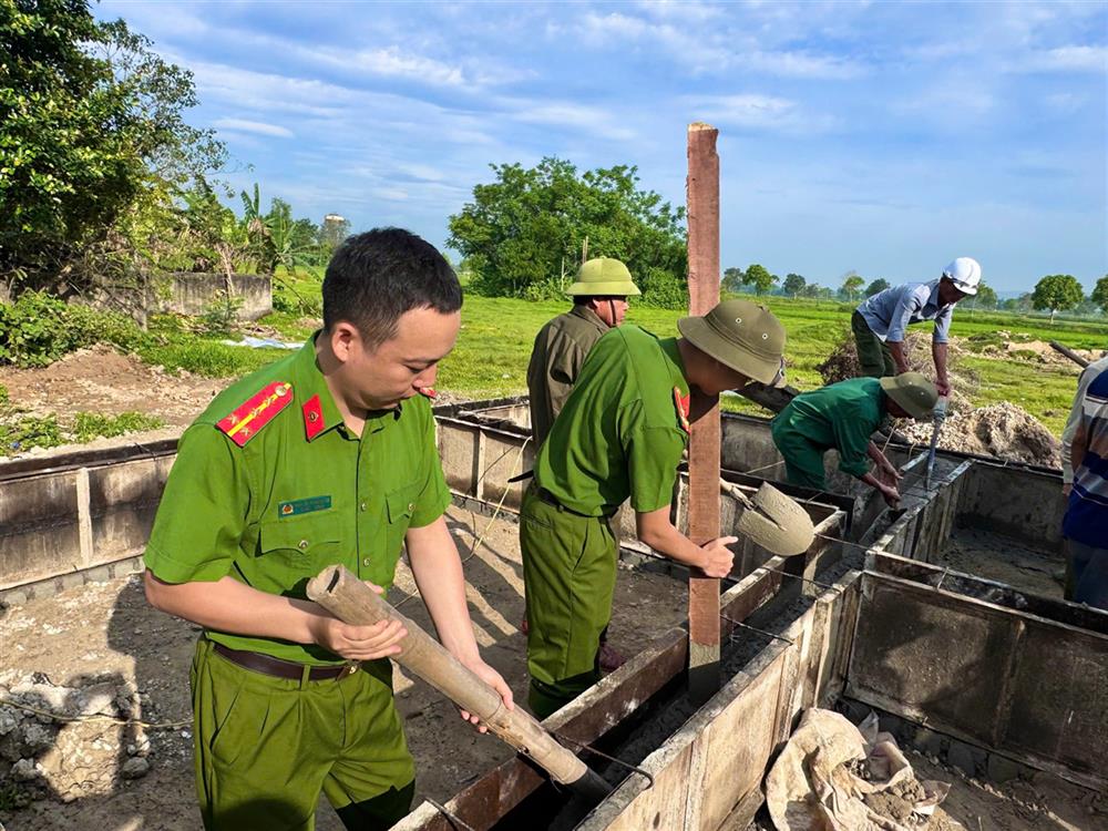 Lực lượng Công an xã hỗ trợ thi công xây dựng nhà ở cho hộ nghèo.
