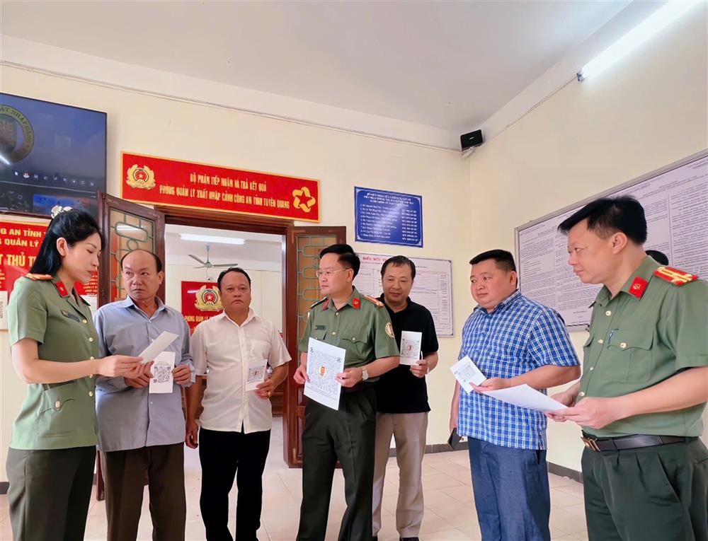 Cán bộ chiến sĩ Phòng Quản lý xuất nhập cảnh hướng dẫn Nhân dân sử dụng QR code.