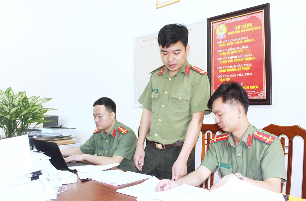 Đại úy Lê Huy Thắng (đứng giữa) thường xuyên trao đổi kinh nghiệm, kiến thức pháp luật với đồng đội phục vụ nhiệm vụ chuyên môn.