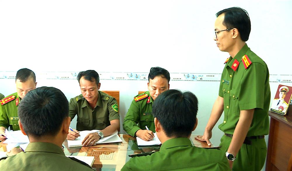 Thiếu tá Nguyễn Vũ Long họp bàn và lực lượng tham gia bảo vệ ANTT ở cơ sở triển khai nhiệm vụ phòng chống tội phạm.