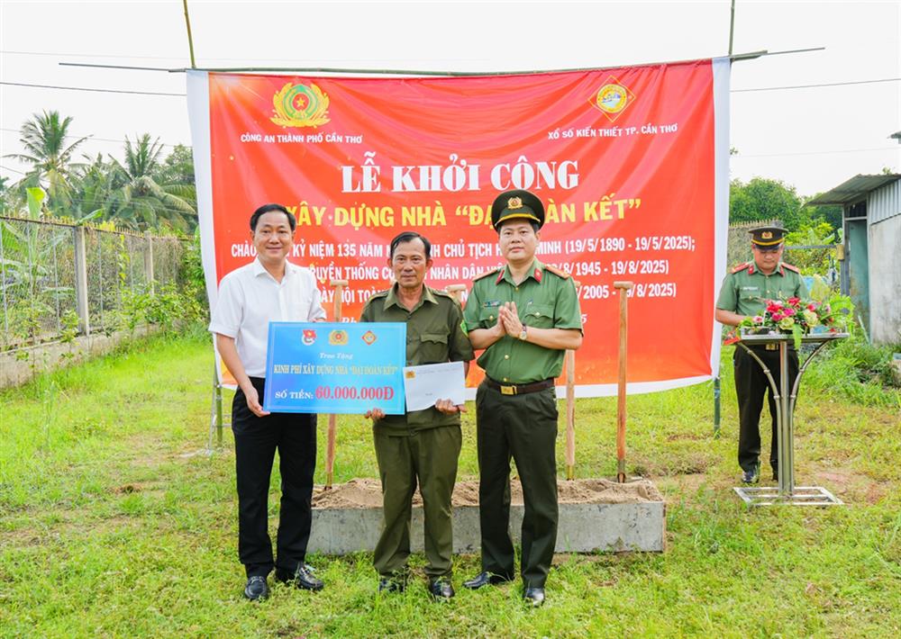 Trung tá Đinh Tùng An, Phó Giám đốc Công an thành phố và ông Trần Minh Tâm, Chủ tịch Công ty TNHH Nhà nước MTV XSKT Cần Thơ trao kinh phí xây nhà tặng ông Nguyễn Hùng Dũng.