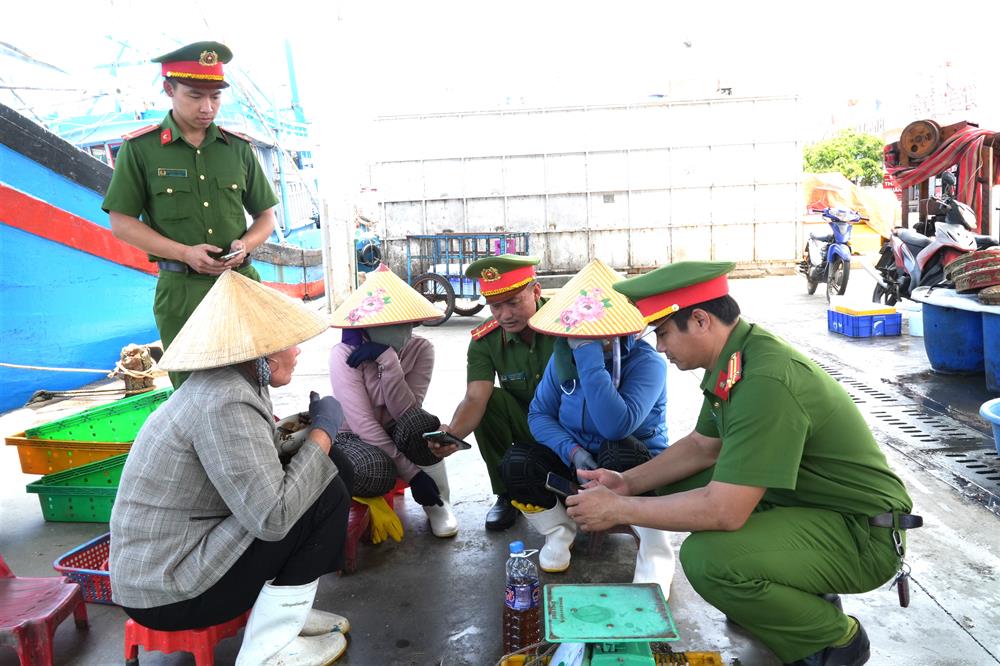 Công an phường đến tận cảng cá tuyên truyền, hướng dẫn người dân tham gia góp ý sửa đổi Hiến pháp.