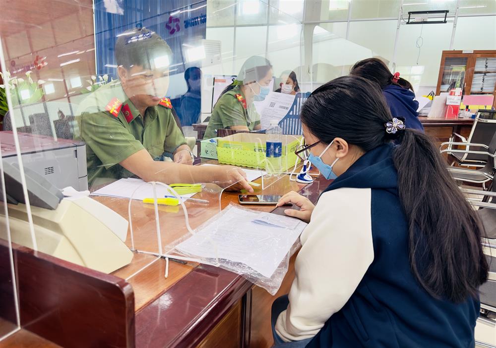 Lực lượng Công an hướng dẫn người dân đăng ký cấp Phiếu lý lịch tư pháp qua ứng dụng VNeID trên điện thoại.