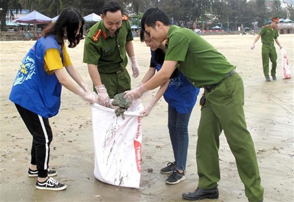 Cán bộ, chiến sỹ Đội 6 Phòng Cảnh sát phòng, chống tội phạm về môi trường cùng đoàn viên, thanh niên quận Đoàn Đồ Sơn thu gom rác trên bãi biển.
