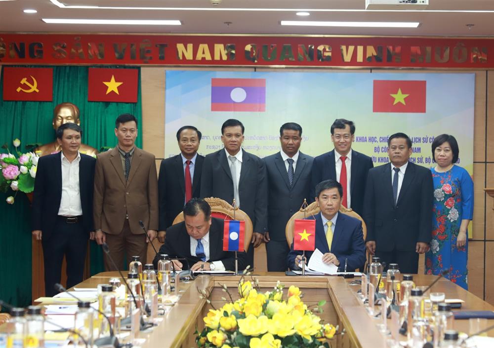 Trung tướng, PGS. TS. Trần Vi Dân và Thiếu tướng, ThS. Sa Vanh Phôm Mạ Li ký biên bản làm việc.