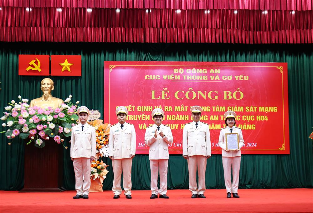 Thiếu tướng Lê Khắc Thuyết trao Quyết định về chức năng, nhiệm vụ, tổ chức bộ máy của Trung tâm giám sát mạng truyền dẫn ngành Công an cho các đồng chí lãnh đạo Trung tâm.