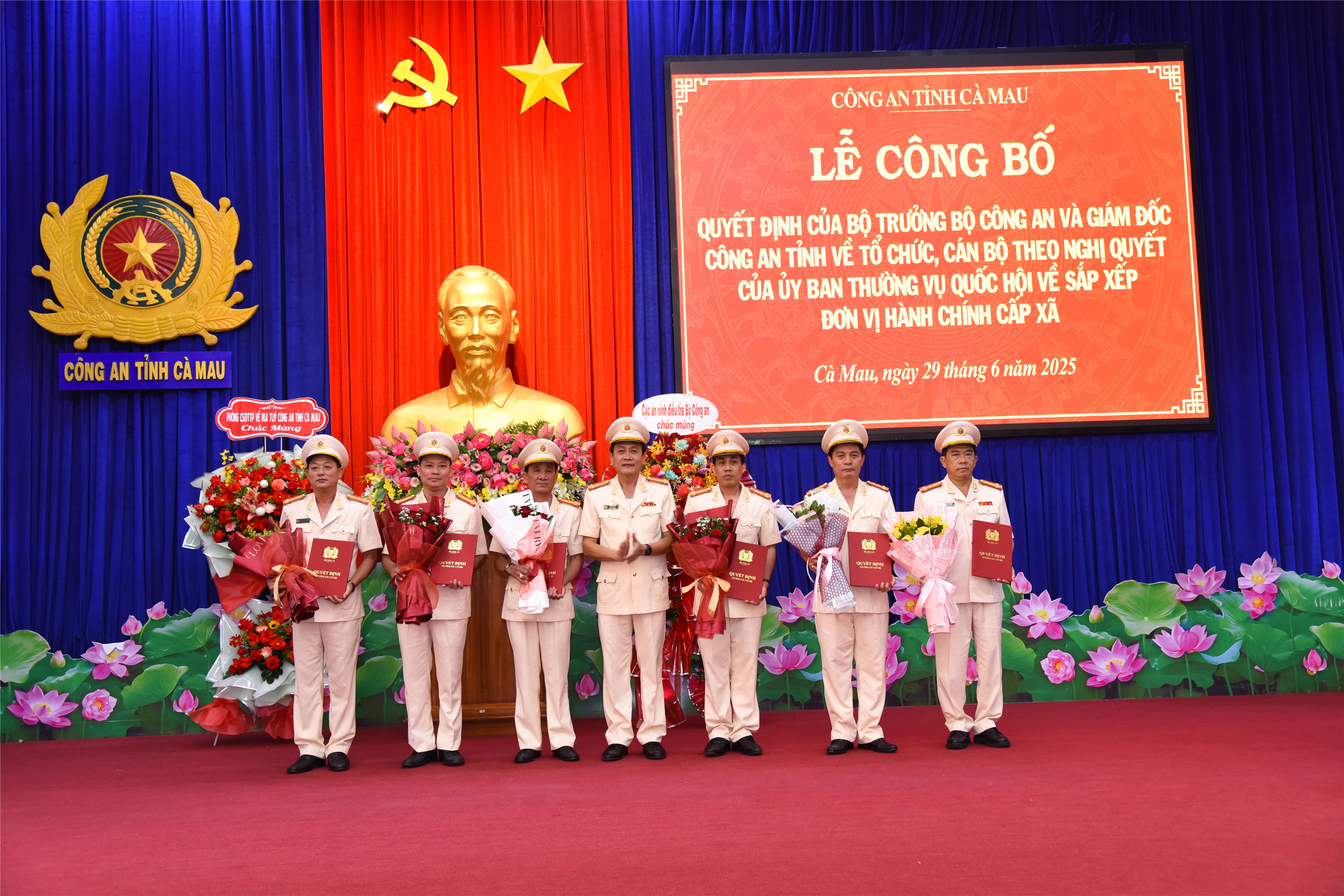 Đại tá Hồ Việt Triều trao quyết định, tặng hoa các đồng chí Phó Giám đốc Công an tỉnh.