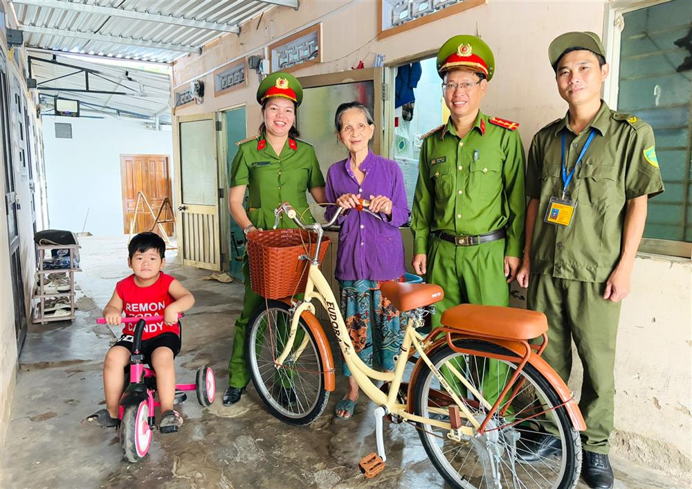 Công an phường Ninh Đa trao tặng chiếc xe đạp cho bà Nguyễn Thúy Nguyên.