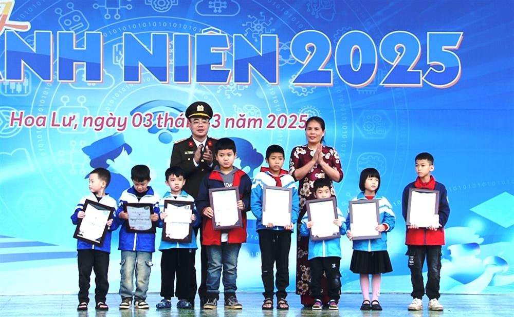 Đại tá Trần Hồng Phú, Phó Giám đốc Công an tỉnh và đồng chí Hà Thị Hoa Lý, đại diện Công ty Bảo Việt Nhân thọ Ninh Bình tặng học bổng cho các em học sinh.