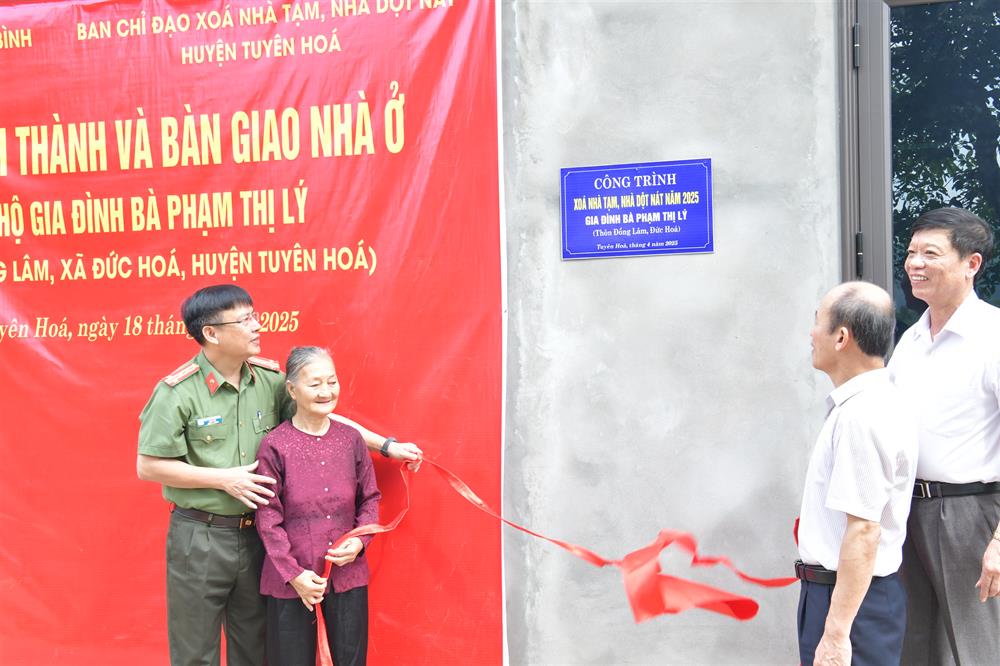 Đại tá Nguyễn Thanh Liêm và lãnh đạo huyện Tuyên Hóa cùng gia đình bà Phạm Thị Lý kéo băng khánh thành, bàn giao nhà.