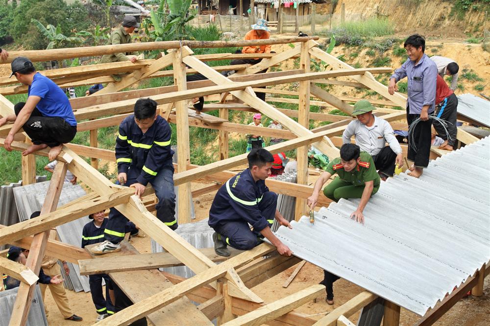 Đoàn viên thanh niên Công an tỉnh Yên Bái tham gia vận chuyển nguyên vật liệu và hỗ trợ người dân xóa nhà tạm, nhà dột nát.