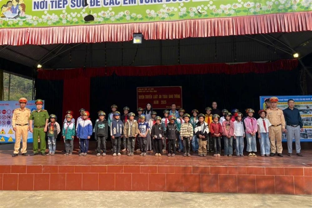Cán bộ Đội CSGT đường bộ số 1, Phòng CSGT Công an tỉnh, Công an xã Nùng Nàng và lãnh đạo Nhà trường trao mũ bảo hiểm cho các em học sinh nghèo.