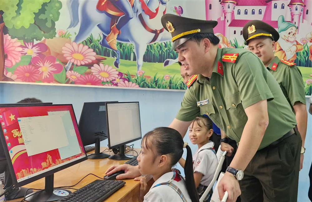 Thượng tá Đồng Đức Vũ, Trưởng ban Thanh niên CAND hướng dẫn học sinh sử dụng máy tính tại buổi trao tặng.